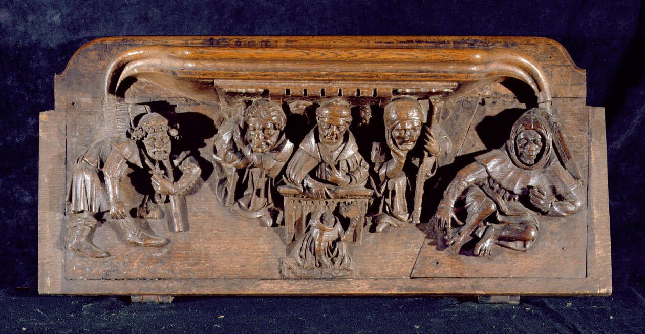 Kurjuus, joka kuvaa akateemikkoa istumassa paneelipöydän ääressä ja pitämässä varoitusta polvistuvalle katuvalle, New College Chapel, Oxford, 1300-luvun loppu (puu) tekijältä English School