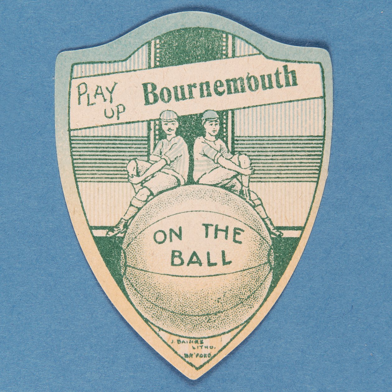 Pelaa Up Bournemouth, Baines -kortti kilven muodossa ja kaksi jalkapalloilijaa istuvat jalkapallon päällä, 1888-89 tekijältä English School