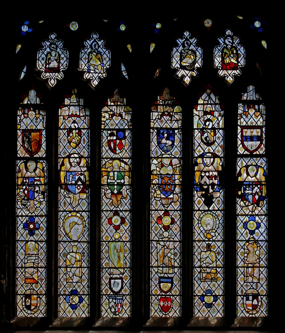 Window St Nectan Chapel Sw, joka kuvaa enkeleitä aseiden kilveineen; nollaa enkelit, päät ja pyöreät. neljä evankelistan symbolia tekijältä English School