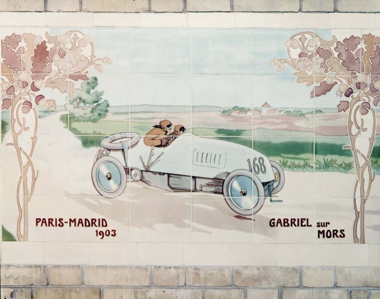 Gabriel ajamassa Mors-autolla Pariisin ja Madridin välisessä, kuoleman kisana tunnetussa kilpailussa vuonna 1903: pariisilaisen Gilardoni Fils et Cie -yhtiön valmistamia keraamisia laattoja Ernest Montautin (1878-1909) piirroksen mukaan. tekijältä Ernest Montaut