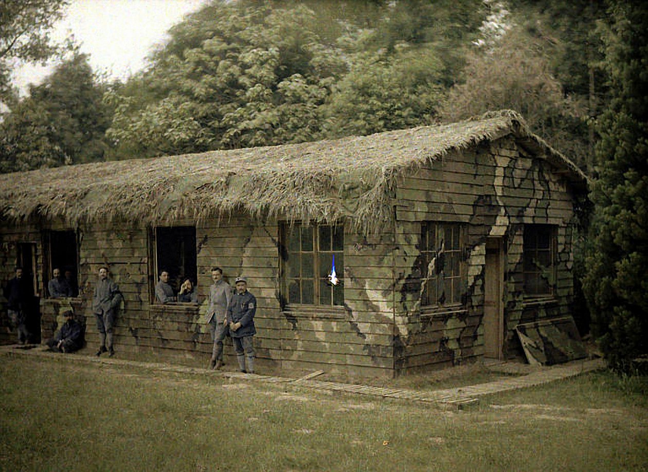 Yhdeksän ranskalaista sotilasta puurakennuksessa, jossa on sotilaallinen naamiointi, Soissons, Aisne, Ranska, 1917 (autokromi) tekijältä Fernand Cuville