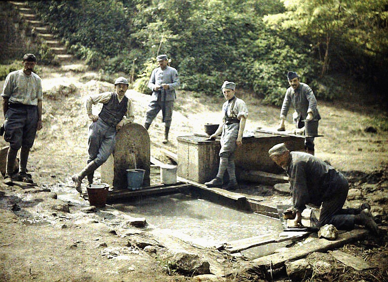 Kuusi ranskalaista sotilasta kauhojen ja pyykin kanssa suihkulähteellä, Soissons, Aisne, Ranska, 1917 (autokromi) tekijältä Fernand Cuville