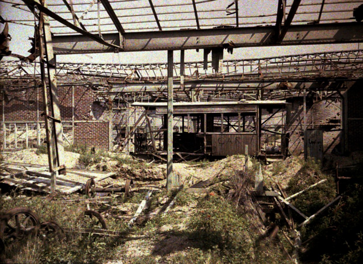 Palanut rautatie- ja raitiovaunupiha, jossa on muutamia vaurioituneita ajoneuvoja ja veturi, Soissons, Aisne, Ranska, 1917 (autokromi) (kuva) tekijältä Fernand Cuville