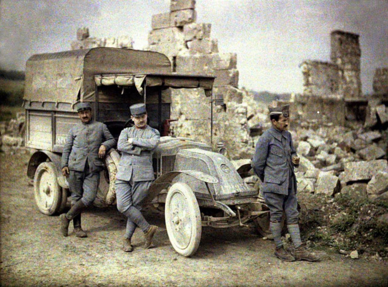 Kolme ranskalaissotilasta pysäköitynä pahoin vaurioituneen rakennuksen eteen pienellä kuorma-autolla, Aisne, Ranska, 1917 (autokromi) tekijältä Fernand Cuville
