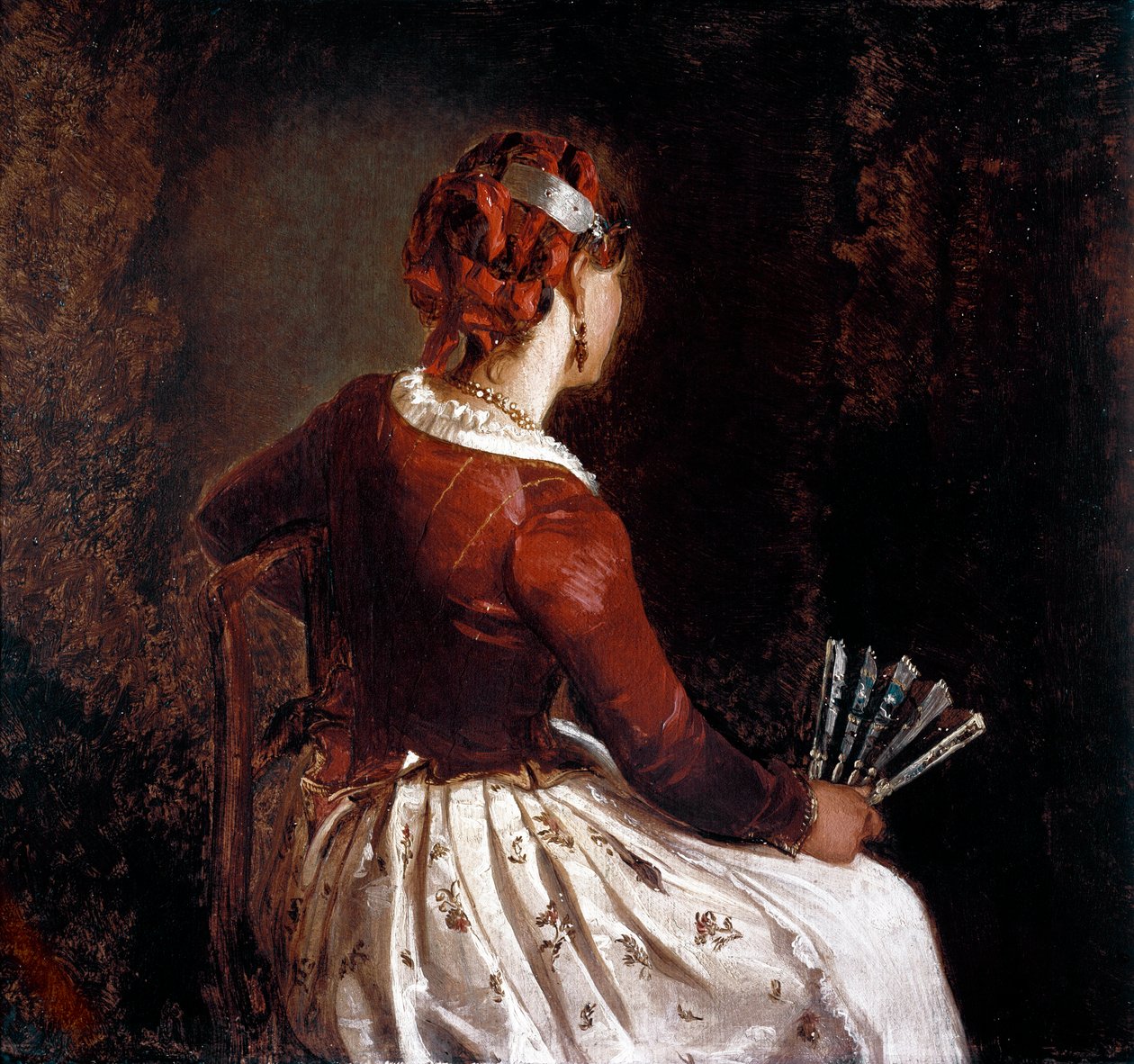 Naisella on tuuletin. Muotokuva istuvasta naisesta kääntynyt takaisin esiliina, hame, jossa kukkia ja punaisia nauhoja hiuksissaan ja viuhka kädessään. Filippo Palizzin (1818-99) maalaus. Roma, Galleria d