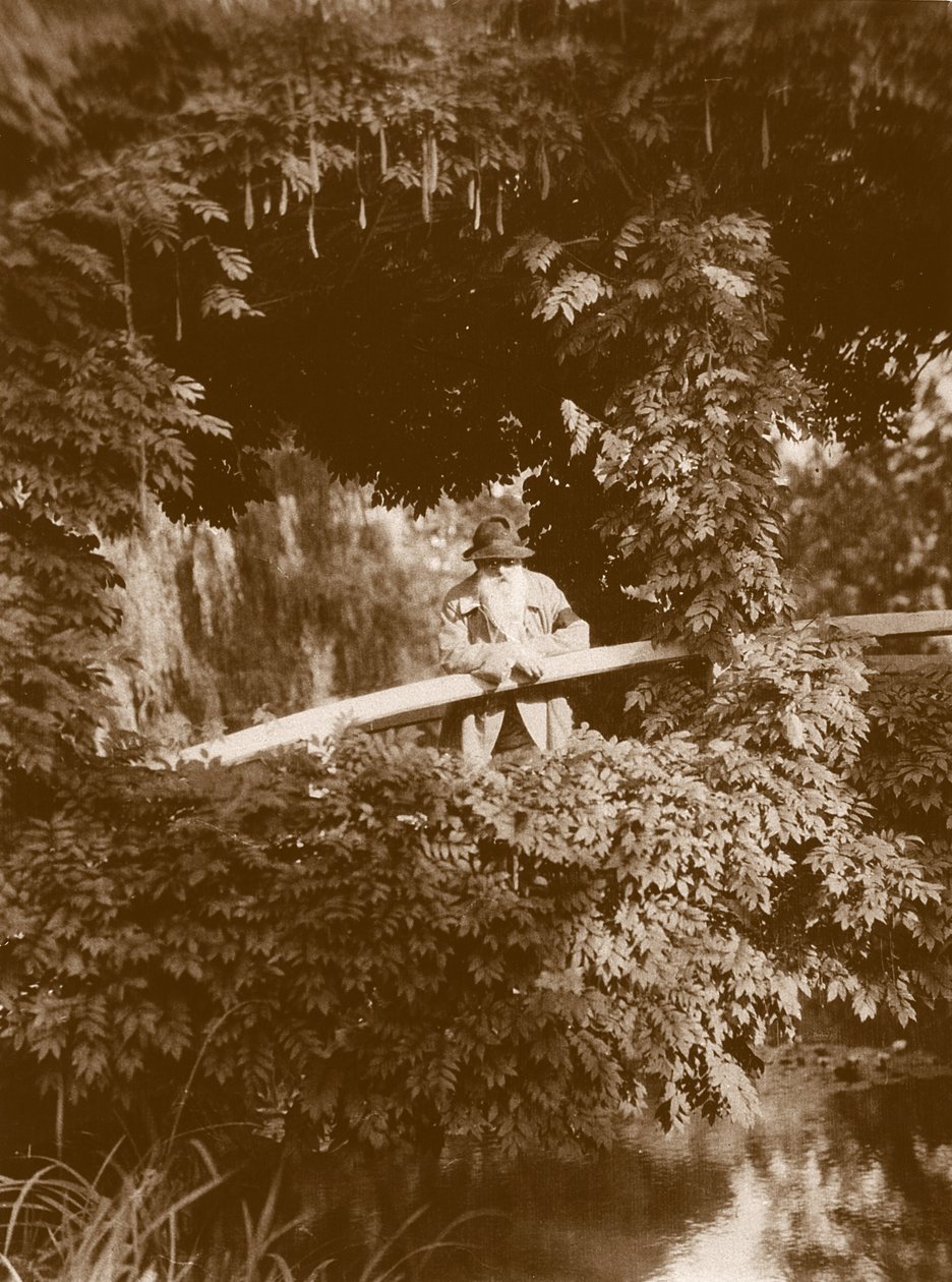 Claude Monet japanilaisella sillalla puutarhassaan Givernyssä, n. 1920 tekijältä French Photographer