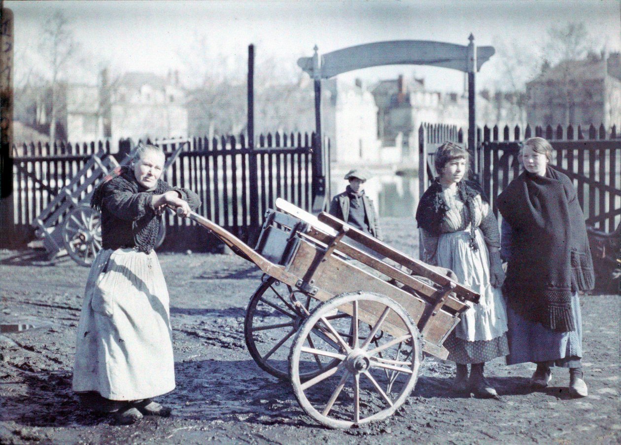 Vanha nainen kärryjen kanssa mutaisella tiellä, kaksi tyttöä ja poika, Ranska, 1914-18 (luonnonvalokuvamaalaus). tekijältä French Photographer