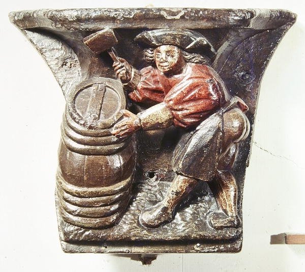 Misericord kuorokopista, joka kuvaa miestä vasaralla piippua, Saint-Etienne des Tonneliersin kirkosta Rouenista (monivärinen puu) tekijältä French School