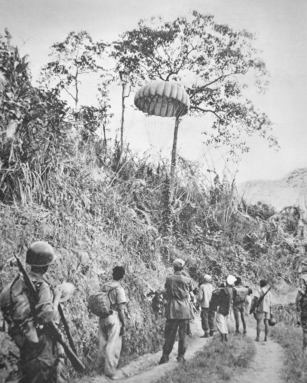 Ranskalaiset ja vietnamilaiset sotilaat löytävät heille laskuvarjolla syötettyjä tarvikkeita Dien Bien Phun piirityksen aikana marraskuusta 1953 toukokuuhun 1954 (m/v kuva) tekijältä French Photographer