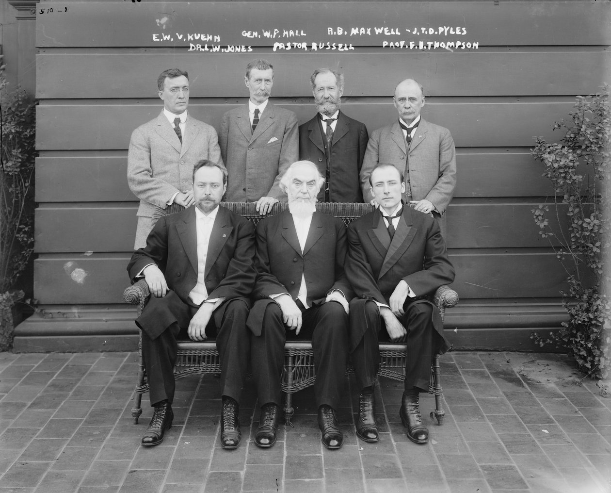 Charles Taze Russell (keskellä) ja Ernest Wilson V. Kuehn, kenraali William P. Hall, Robert B. Maxwell, J.T.D. Pyles, tohtori Leslie W. Jones, professori F.B. Thompson, 1911 tekijältä George Grantham Bain
