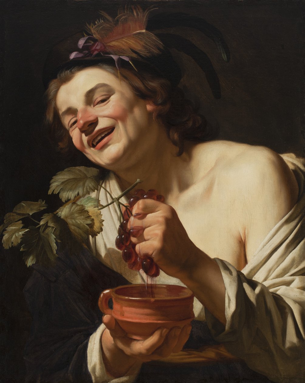 Hymyilevä nuori mies puristamassa viinirypäleitä, 1622 tekijältä Gerrit van Honthorst