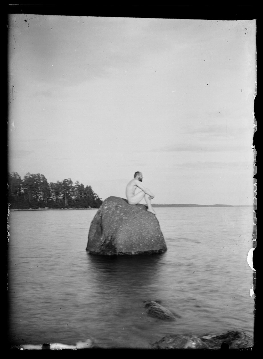 Hugo Simberg istuu kiven päällä, Essaari ja Suonionsaari taustalla tekijältä Hugo Simberg