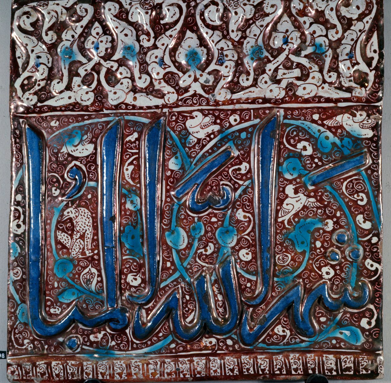 Islamilainen taide: seinäkeraamiset laattaemalityyppiä "" lajvardina"" (lapis-lazuli), jossa on merkintä "" The month of God Beni""" Kashanista, Iranista. 13. vuosisadalla. Himmeä. 36x36 cm Teheranin arkeologinen museo, Iran tekijältä Islamic School