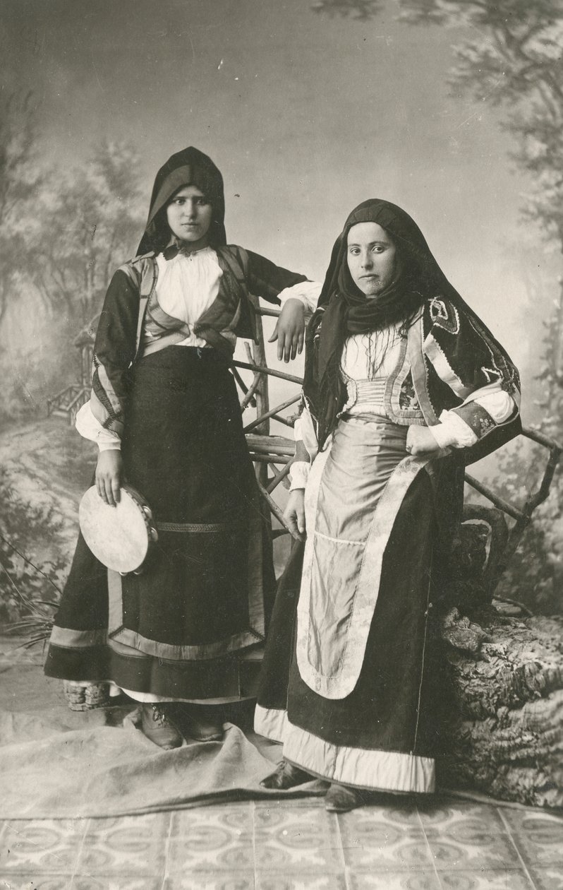 Kaksi naista pukeutuneena perinteisiin vaatteisiin Belvistä ja Aritzosta, Sardiniasta, Italiasta, n. 1910. tekijältä Italian Photographer