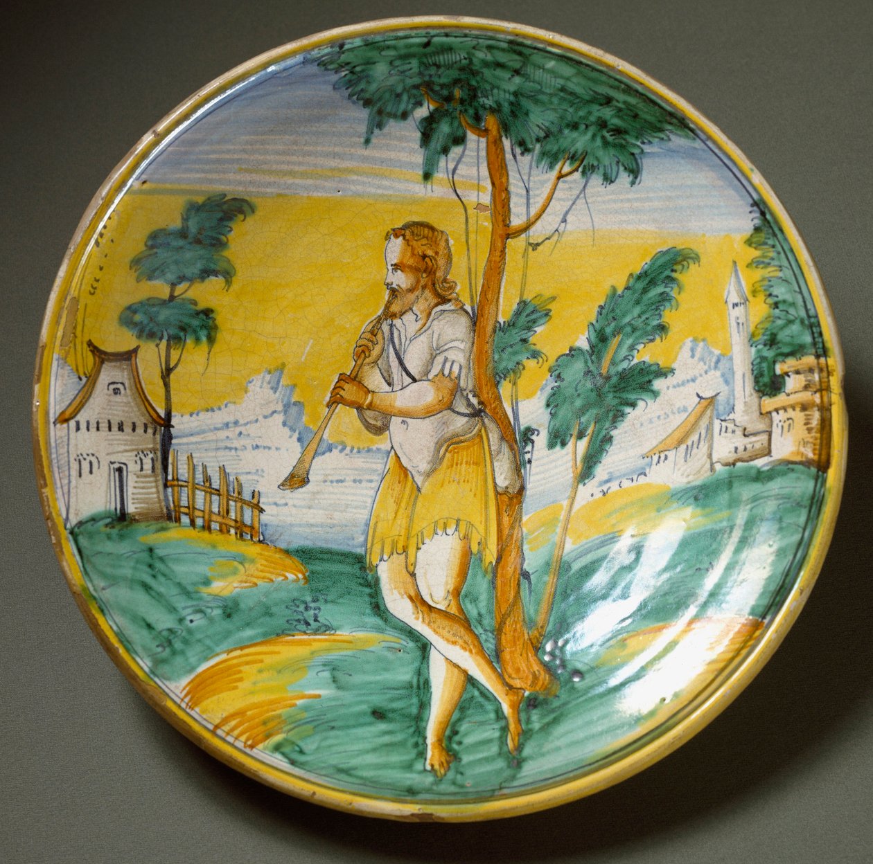Huilusoittaja maisemassa. Keraaminen levy valmistettu Viterbossa, Italiassa. 1500-luvun loppu Firenze, Museo Nazionale del Bargello tekijältä Italian School