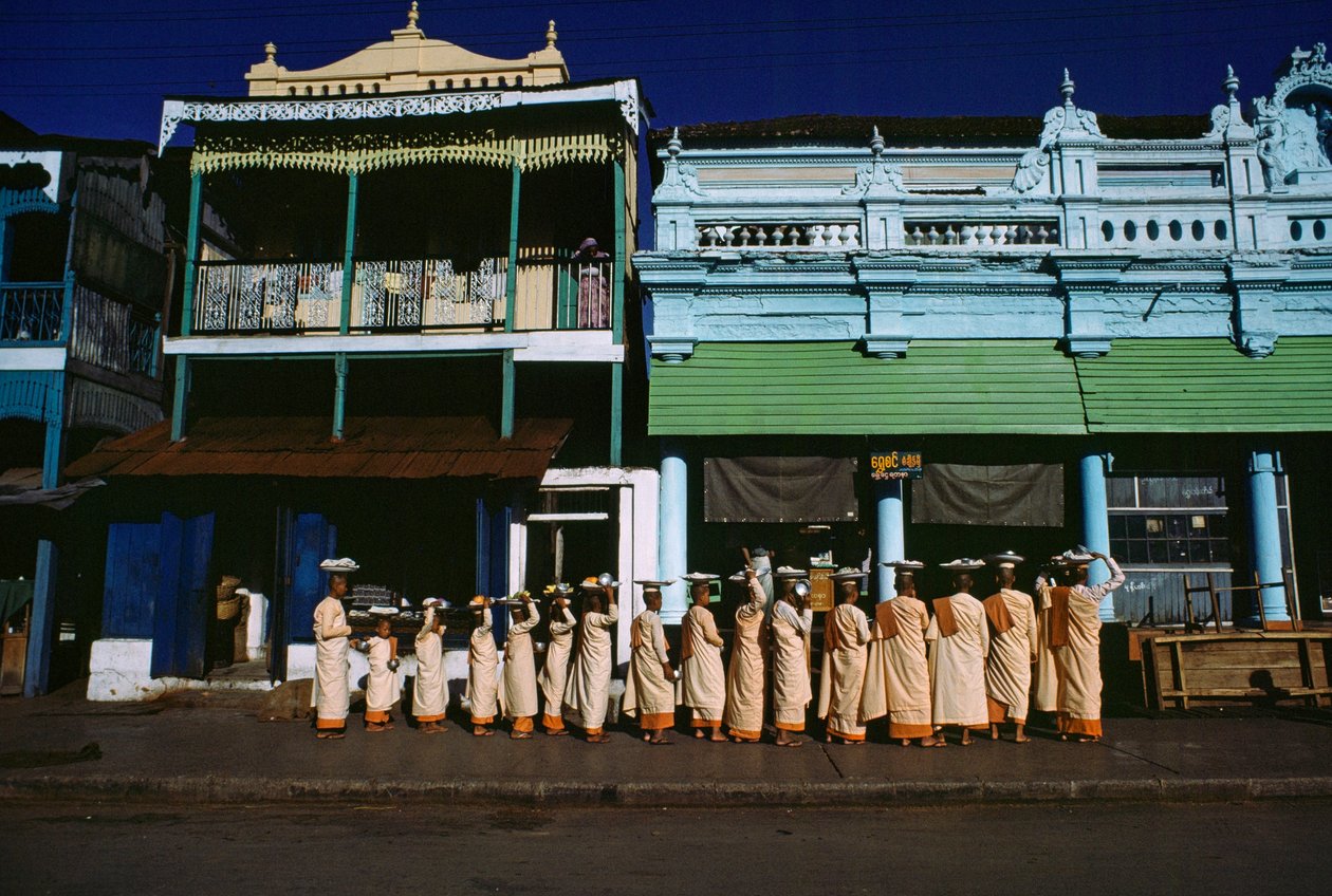 Eri-ikäiset buddhalaisnunnat kulkevat jalkakäytävällä pyytämässä almuja. Maymyo, Burma. tekijältä James L Stanfield