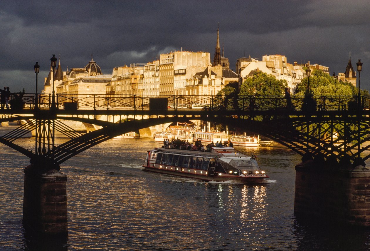 Tummia pilviä näkyy, kun vene kulkee Pont des Artsin alitse. Seine-joki, Pa... tekijältä James L Stanfield