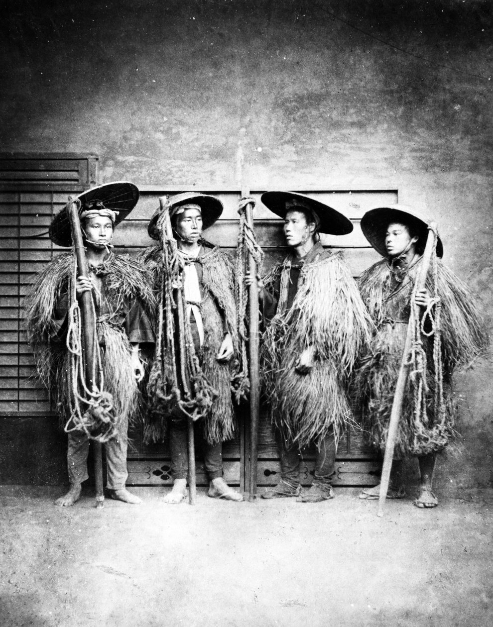 Japanilaiset miehet olkitakkeissa, noin 1870-luku tekijältä Japanese Photographer
