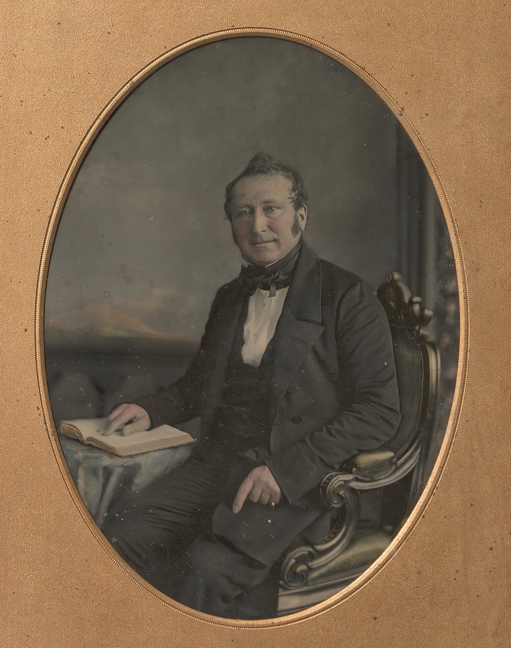 Istuva mies osoittaa kohtaa avoimessa kirjassa, 1850-luku. tekijältä John Jabez Edwin Mayall