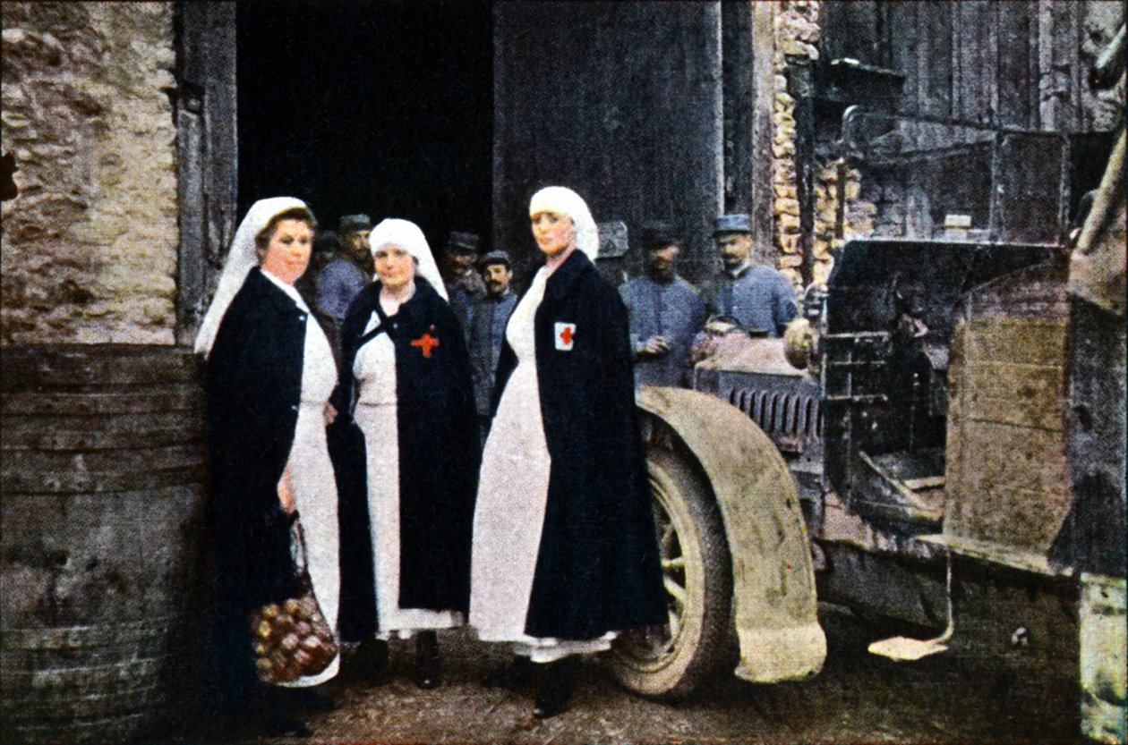 Kolme punaisen ristin pukeutunutta naista ja ranskalainen ambulanssihenkilöstö ajoneuvon kanssa, Verdun, syyskuu 1916 (autokromi) tekijältä Jules Gervais Courtellemont