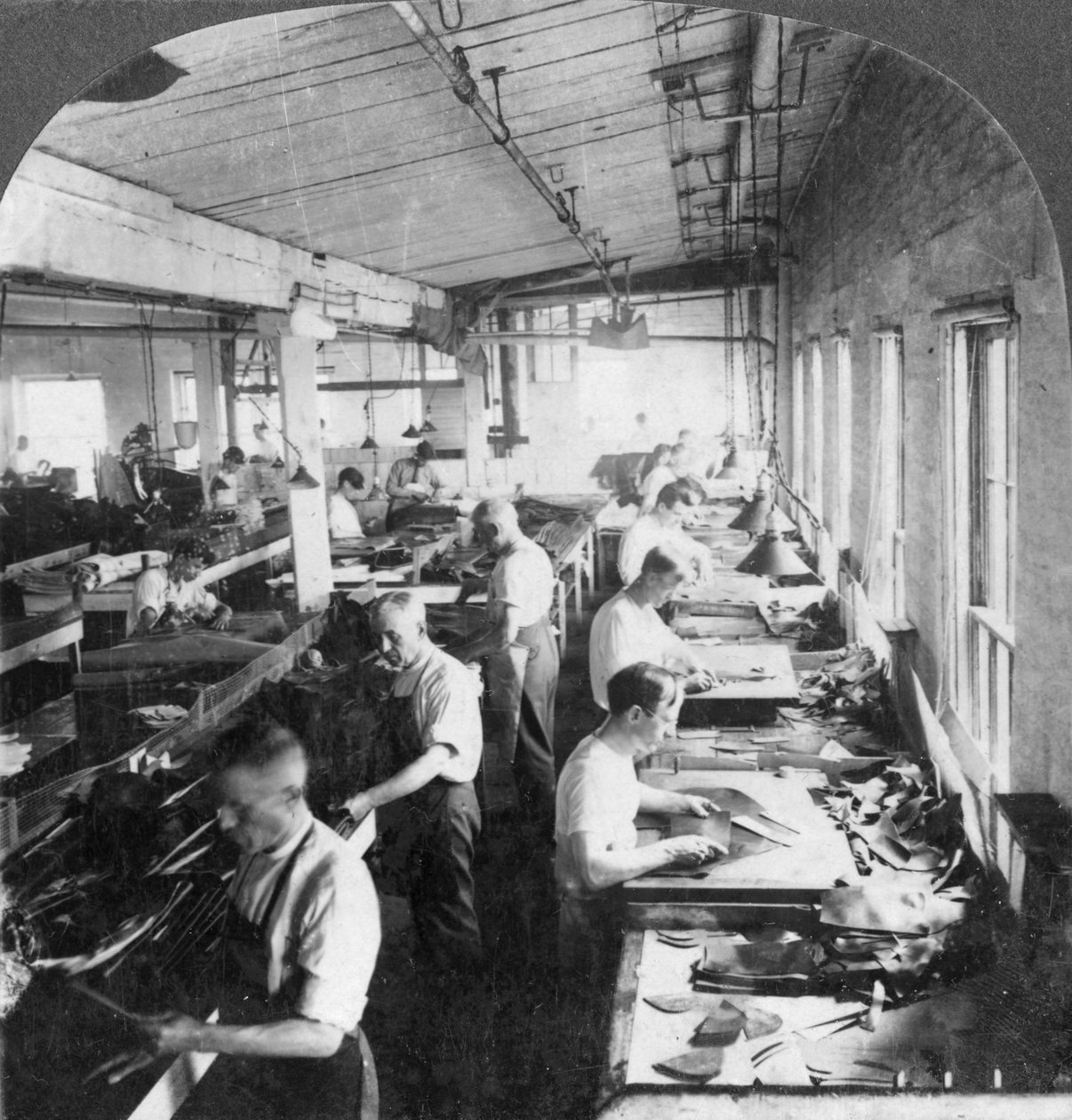 Työntekijät leikkaamassa nahkaa kenkiä varten tehtaalla, Lynn, Massachusetts, USA, 1900-luku tekijältä Keystone View Company