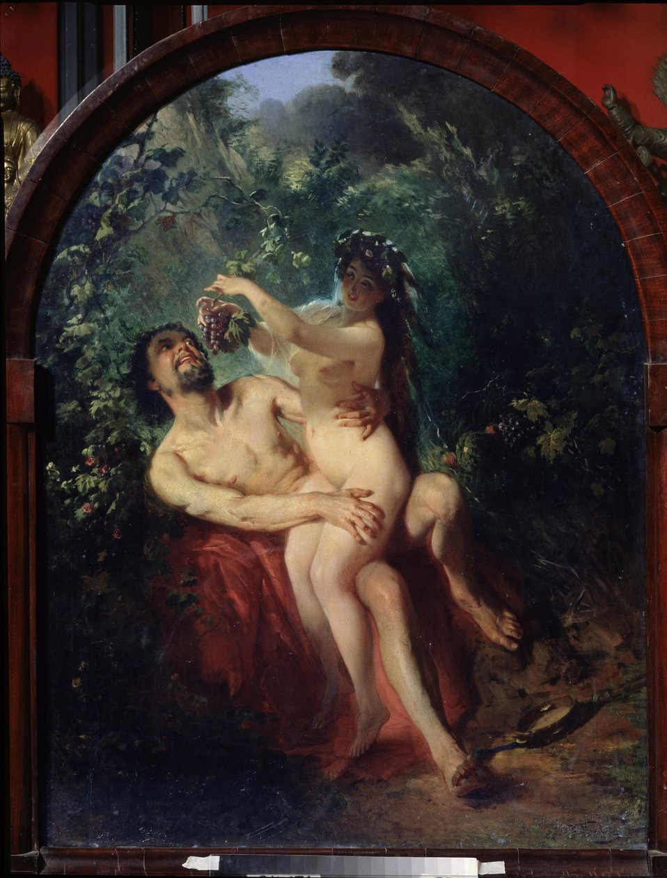 Satyr ja nymfi. (Satyr ja Nymfi). Alaston ja humalassa pariskunta, satyyrin polvilla oleva nymfi ruokkii häntä rypäletertulla, joka on poimittu niitä ympäröivistä viiniköynnöksistä. Maalaus: Konstantin Jegorovich Makovski (Constantin Makovsky) (1839-1915), tekijältä Konstantin Egorovich Makovsky