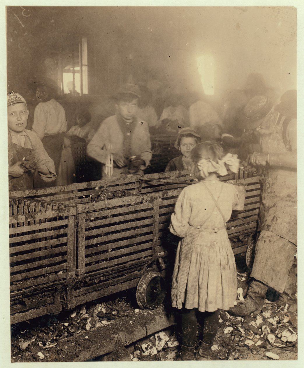 Lowden Canning Companyn tehdas, Bluffton, Etelä-Carolina, näyttää 7-vuotiaan tytön, joka syö 3 ruukkua ostereita päivässä 6-vuotiaan veljensä kanssa ja 11-vuotiaan pojan, joka tekee 6 ruukkua, 1913 (bw p tekijältä Lewis Wickes Hine