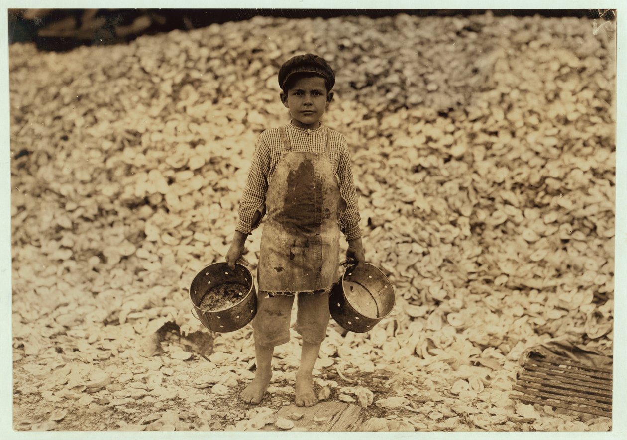 5-vuotias siirtolainen katkarapupoimija Manuel osterinkuoren kasan edessä, työskennellyt toisen vuoden Dunbarissa, Lopezissa, Dukate Companyssa, Biloxissa, Mississippissä, 1911 tekijältä Lewis Wickes Hine