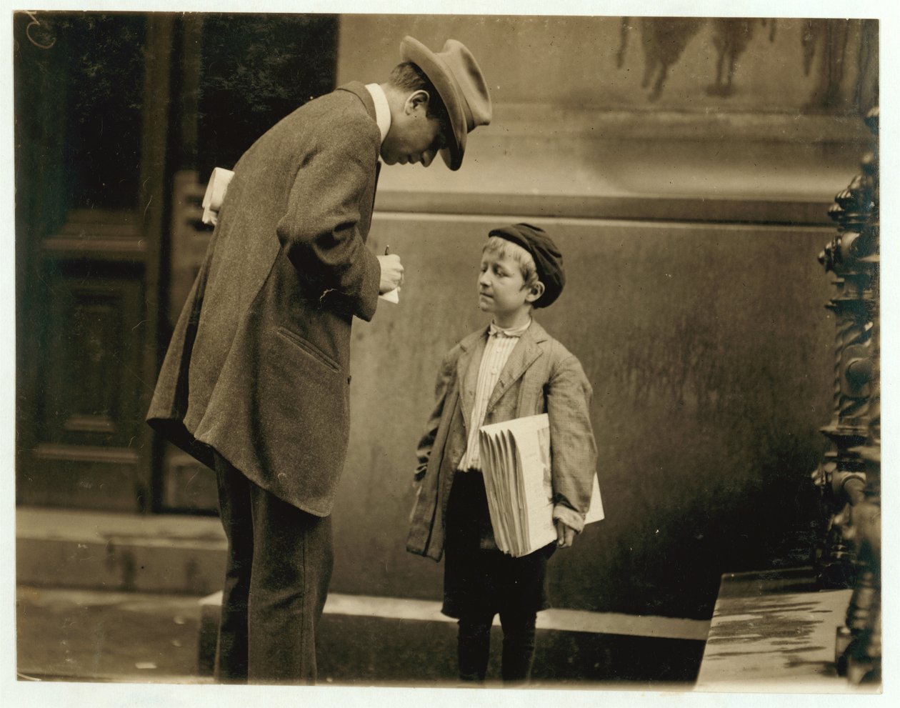 8-vuotias sanomalehtipoika Michael McNelis, joka oli juuri toipunut toisesta keuhkokuumekohtauksestaan ja myi papereita sademyrskyssä, Philadelphia, Pennsylvania, 1910 tekijältä Lewis Wickes Hine