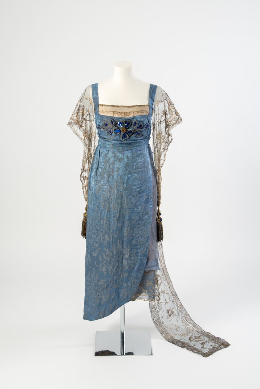 Sinikuvioinen silkki-iltapuku, jossa kultaiset verkkohihat ja kultainen metallinauha brodeerattu ja koristeltu sinisillä jalokivillä ja tupsuilla, 1911 (silkki) tekijältä Lucy Christiana, Lady Duff Gordon