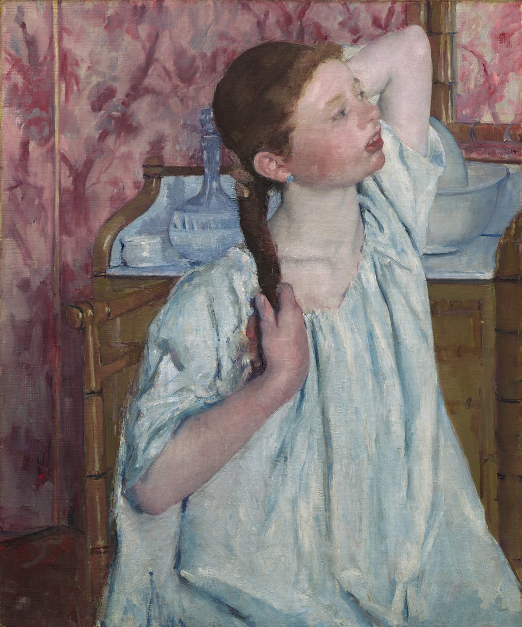 Tyttö järjestelee hiuksiaan tekijältä Mary Cassatt