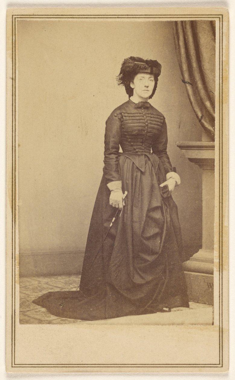 [Tunnistamaton nainen, jolla on hattu ja pitkä tumma mekko.] tekijältä Mathew B. Brady