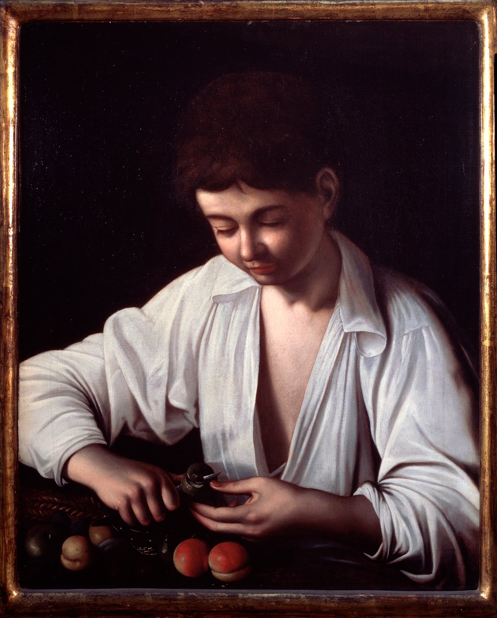 Poika kuorimassa hedelmää tekijältä Michelangelo Merisi da Caravaggio