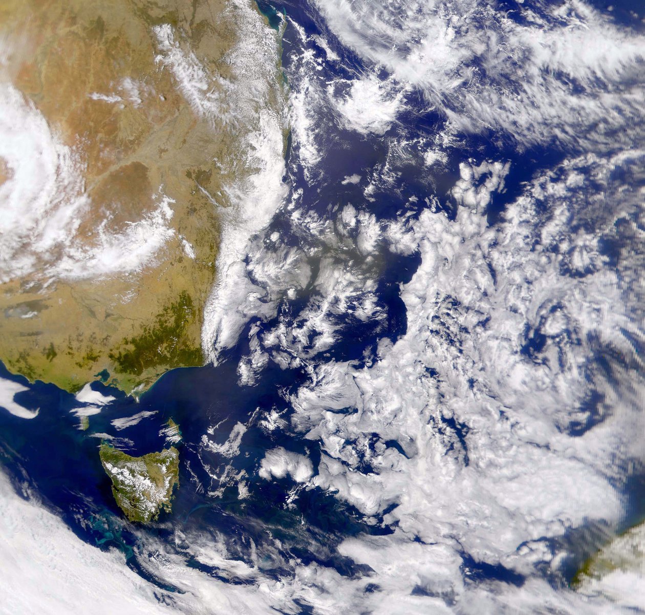 Satelliittikuva Tasmaninmerestä osittain pilven peitossa. Vasemmalla on osa Australiaa ja sen alla Tasmania. NASA. Tiede tekijältä National Aeronautics and Space Administration National Aeronautics and Space Administration