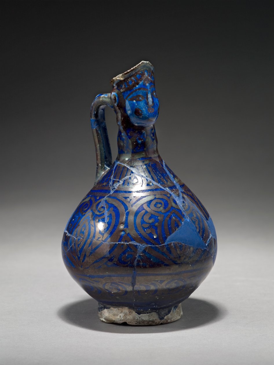 Ihmispäinen kannu, Iran, 1300-luvun alku (kivitahna kullan kiiltävällä sinisellä lasiteella) tekijältä Persian School