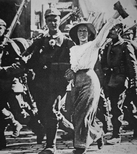Ensimmäisen maailmansodan saksalaiset joukot marssivat sotaan tunikoissaan ja kivääreissään riemuitsevan väkijoukon kukilla tekijältä Photographer German