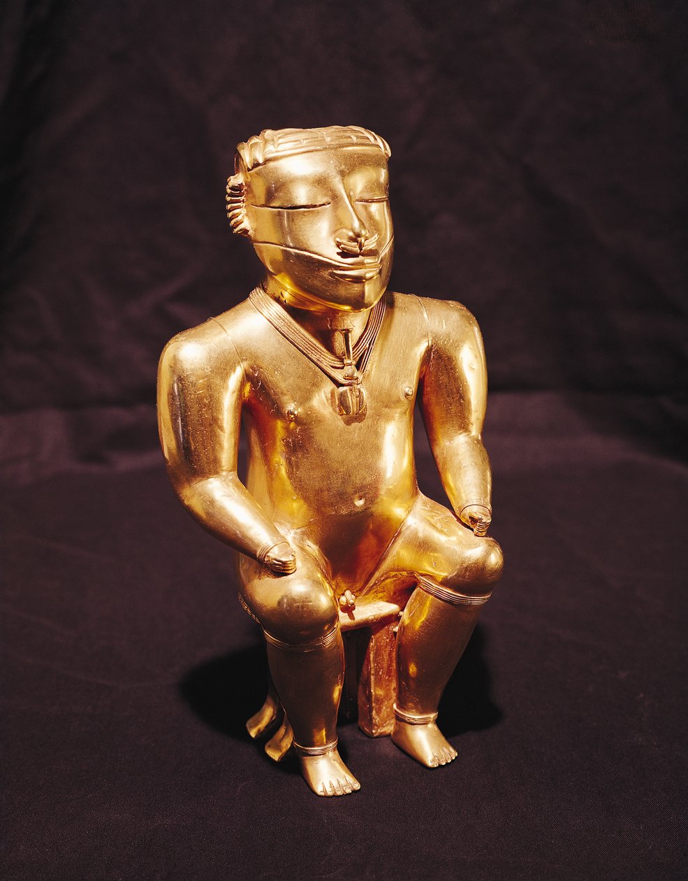 Istuvan miehen patsas, Quimbaya (kulta) tekijältä Pre Columbian