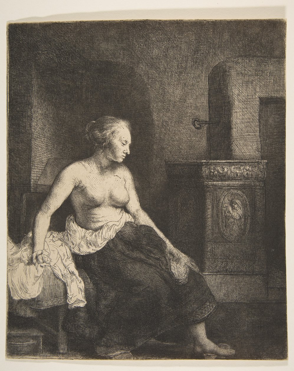 Nainen istuu puolipukeutuneena lieden vieressä, 1658. tekijältä Rembrandt van Rijn