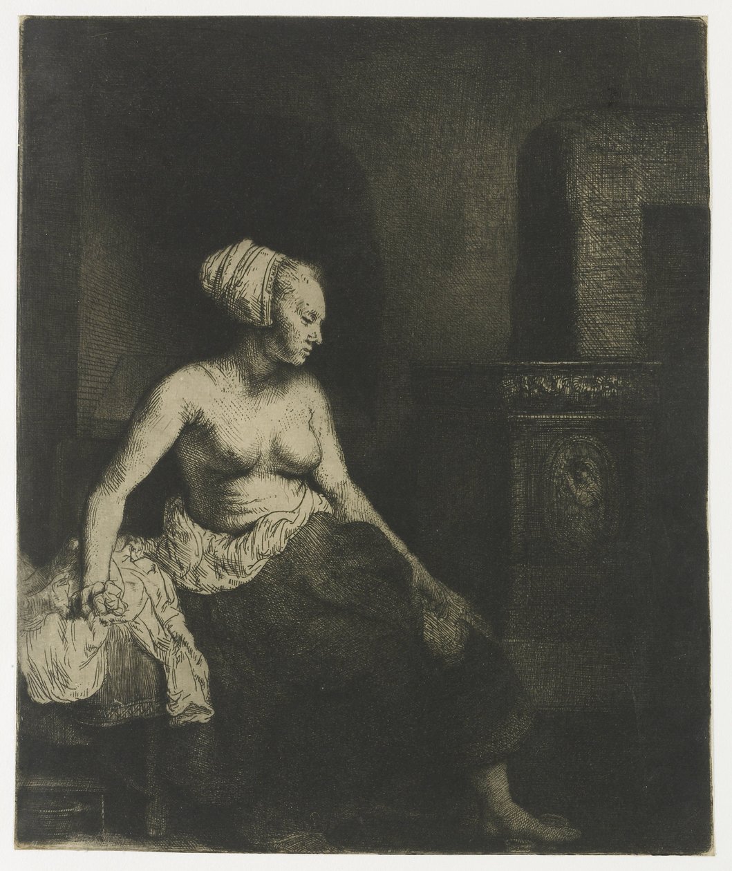 Nainen istuu puolipukeutuneena lieden vieressä tekijältä Rembrandt van Rijn