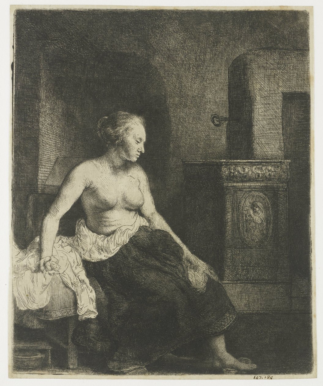 Nainen istuu puolipukeutuneena lieden vieressä tekijältä Rembrandt van Rijn