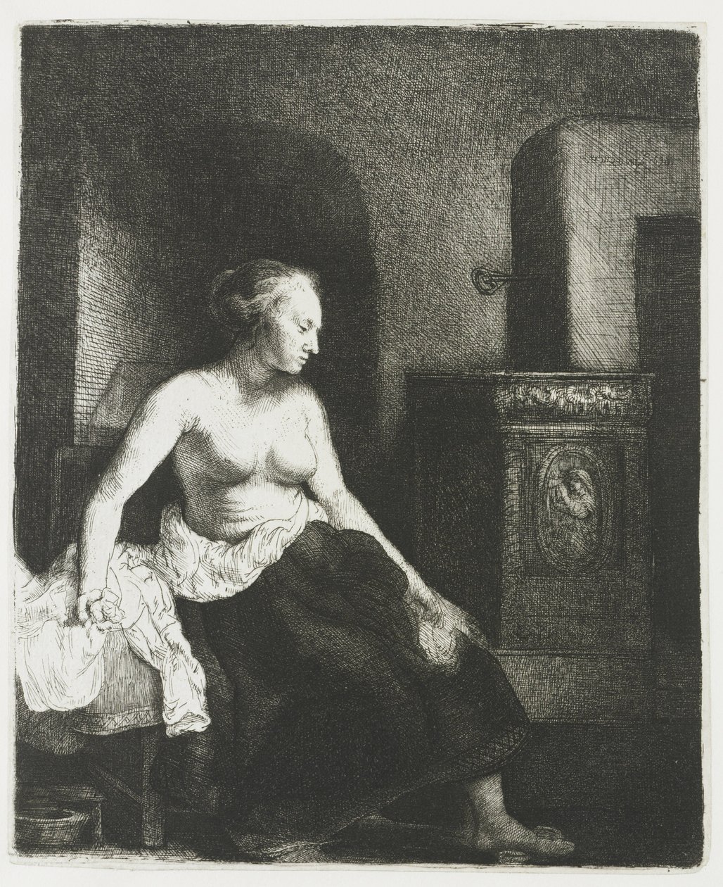Nainen istuu puolipukeutuneena lieden vieressä tekijältä Rembrandt van Rijn