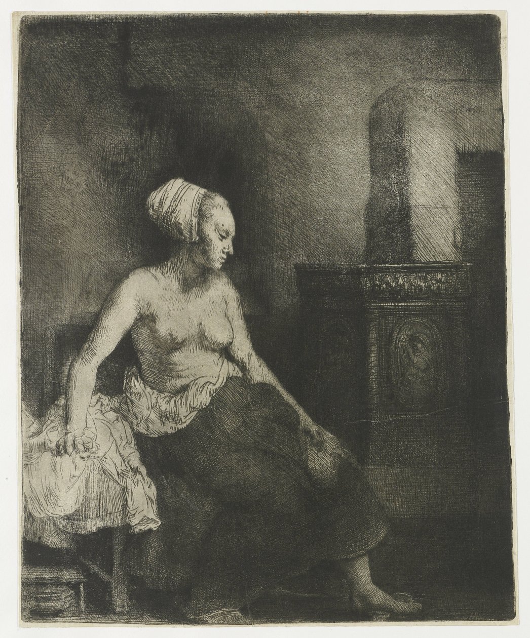 Nainen istuu puolipukeutuneena lieden vieressä tekijältä Rembrandt van Rijn