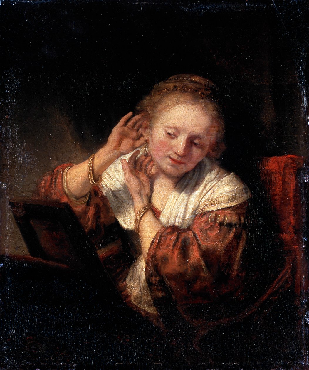Nuori nainen kokeilee korvakoruja, 1657. tekijältä Rembrandt van Rijn