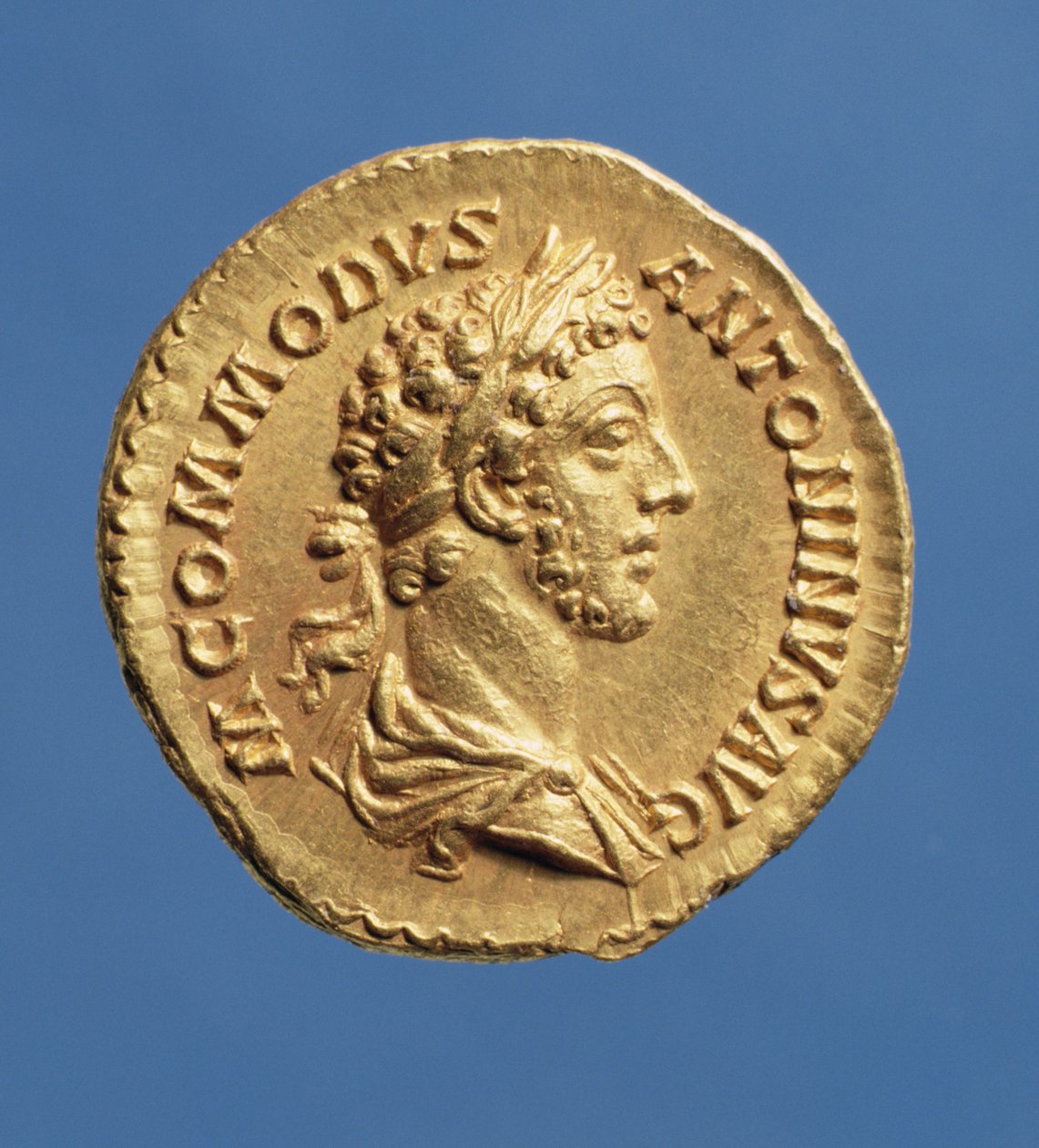 Commoduksen (180-192) Aureus-rintakuva (180-192) drapedoituna, oikealla, laakeriseppeleessä. Kirjoitus: M ANTONINVS COMMODVS AVG (kulta) tekijältä Roman