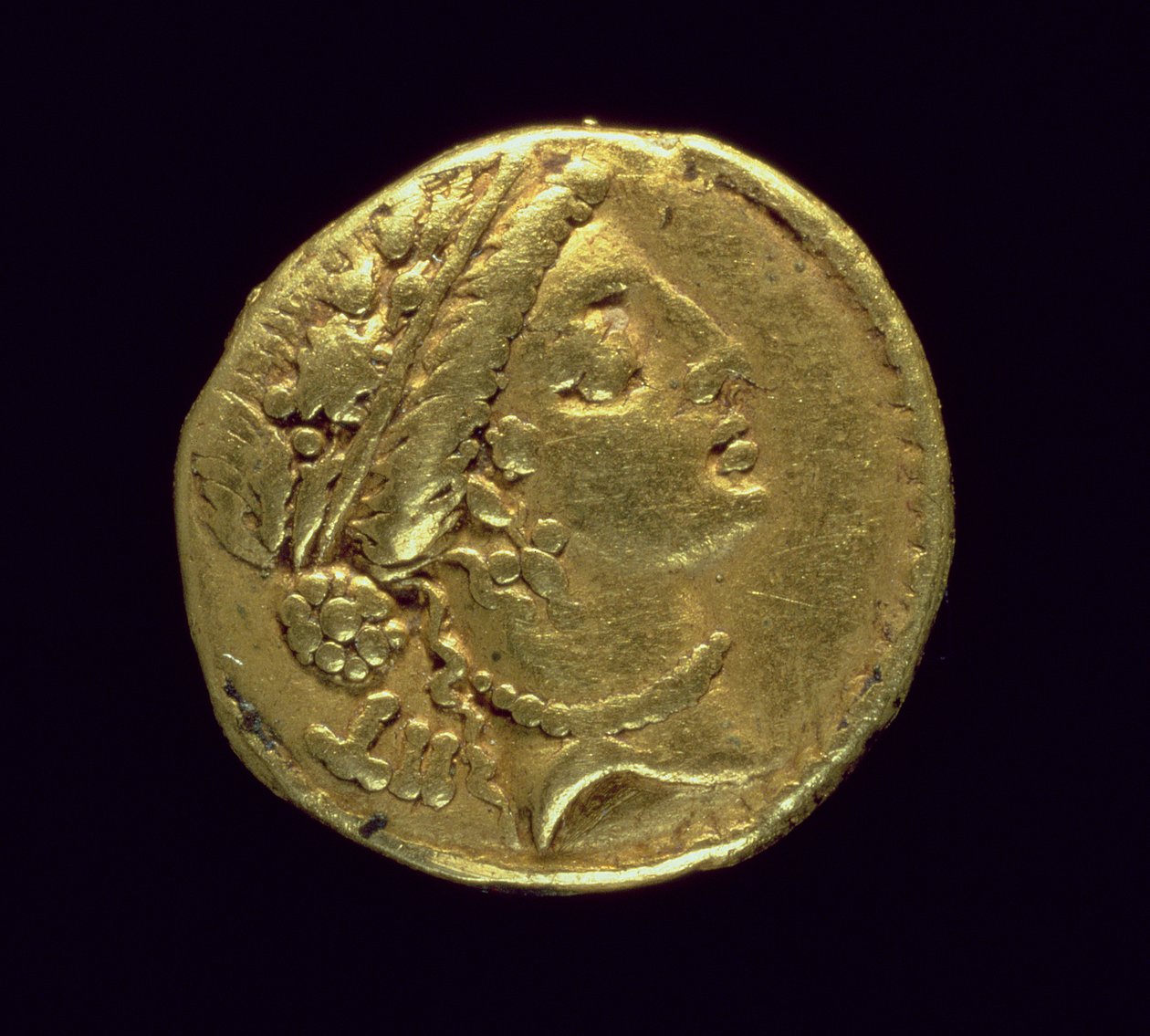 Julius Caesarin (110-44 eKr.) lyömä Aureus (käänsi), joka kuvaa naispuolista päätä, jolla on tammiseppele ja diadeemi (kulta) tekijältä Roman