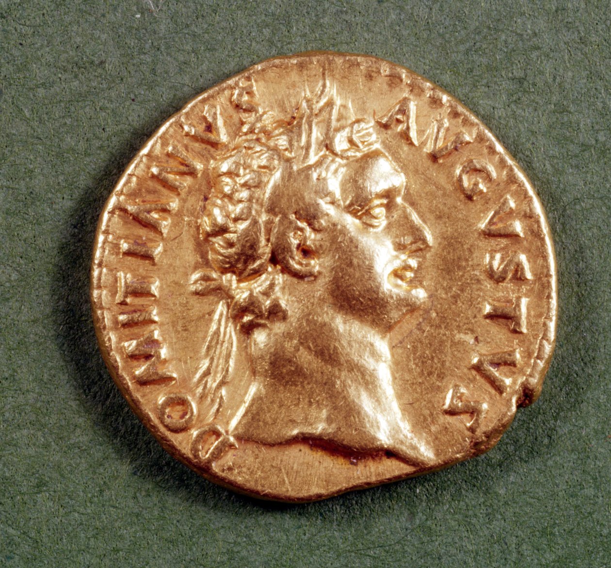 Domitianuksen (81-96 jKr.) Aureus (etupuoli), yllään laakeriseppele. Kaiverrus: DOMITIANVS AVGVSTVS (kulta). tekijältä Roman