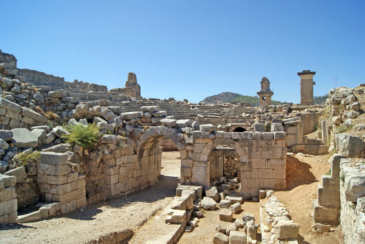 Näkymä Xanthos-teatterin holvikoidusta sisäänkäynnistä orkesterin kaivoon, jossa näkyy pilari ja Harpy-hauta, Xanthos, Turkki (kuva) tekijältä Roman