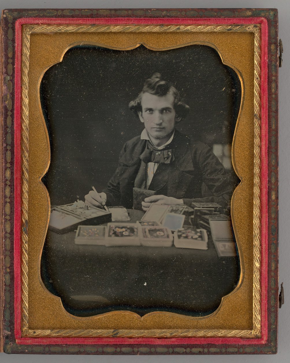 Nimetön muotokuva istuvasta miehestä pitelemässä dagerrotyyppiä ja sivellintä, 1865. tekijältä Samuel J. Miller