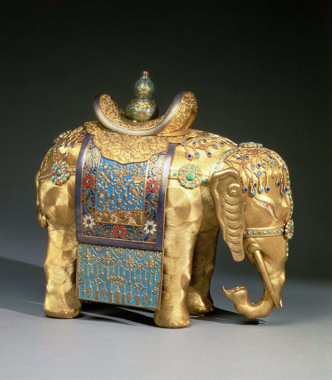 Elefantin figuuri, jossa emalinauhat ja koralli- ja turkoosi cabochons, satulakangas koristeltu buddhalaisilla tunnuksilla, Chien Lung -kausi, n. 1780 (kullattua pronssia, emalia, korallia ja turkoosia) tekijältä School Chinese