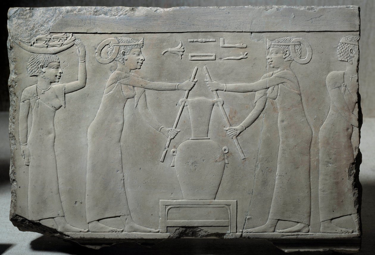 Egyptiläinen antiikki: matala kalkkikivireliefi, joka edustaa naisia, jotka puristavat liljankukkia uuttaakseen "lirinon-uutokseen" kutsuttua esanssia noin 500-400 eKr. (Saiten aikakausi?). Matala aikakausi. Aurinko 0,29x0,37 m Pariisi, musee du Louvre tekijältä School Egyptian